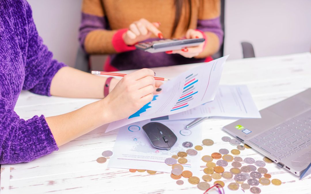 Person calculating business expenses while planning a website development project.